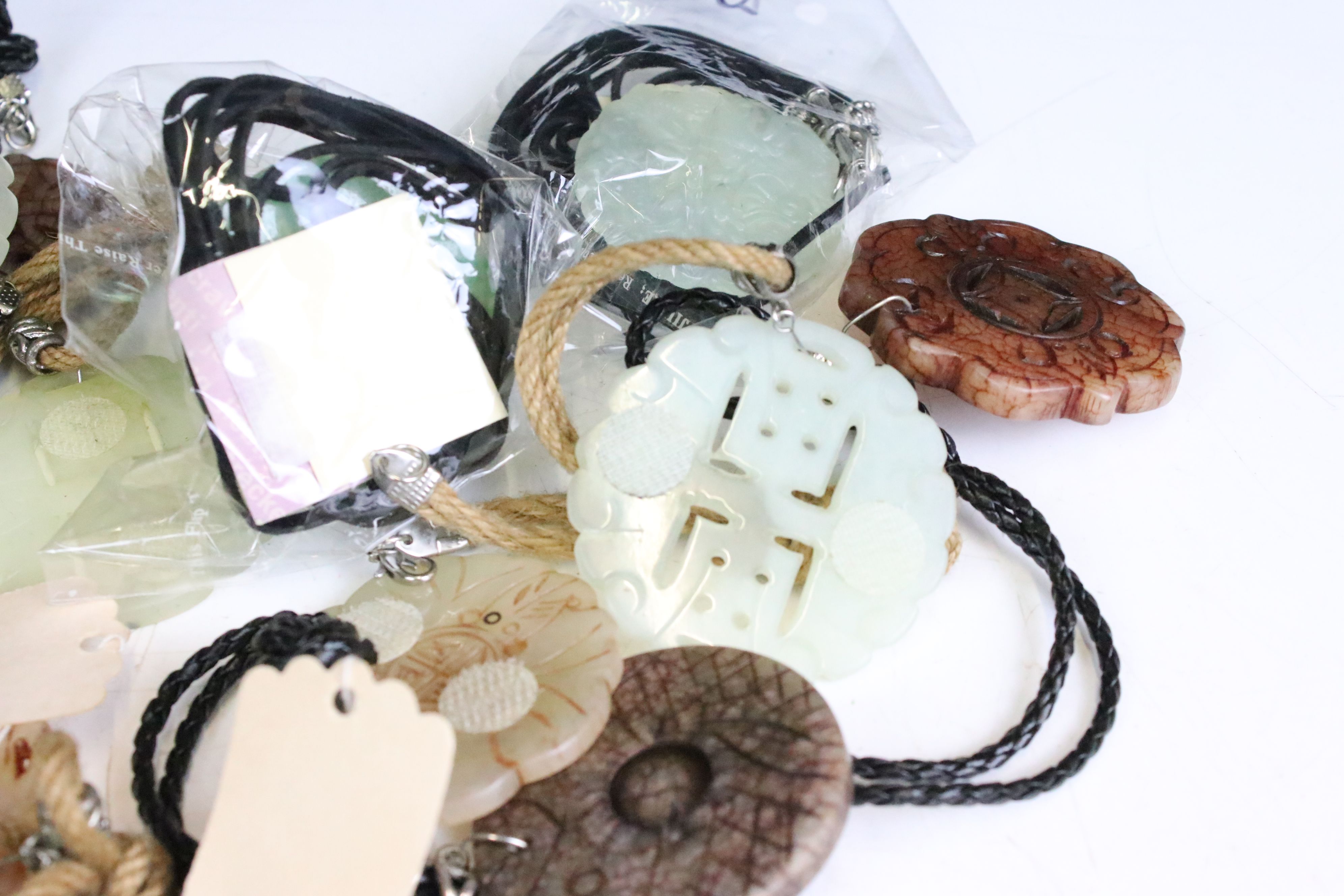 A collection of twenty seven carved jade pendants on leather / hessian necklaces. - Image 5 of 6