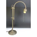 Edwardian brass adjustable desk lamp, with reeded support, raised on a circular base. Measures 55.