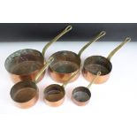 A set of six graduated copper saucepans with brass handles, largest measures 16cm diameter.