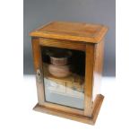 Edwardian oak smokers cabinet, the glazed door opening to two drawers, and upper and lower storage