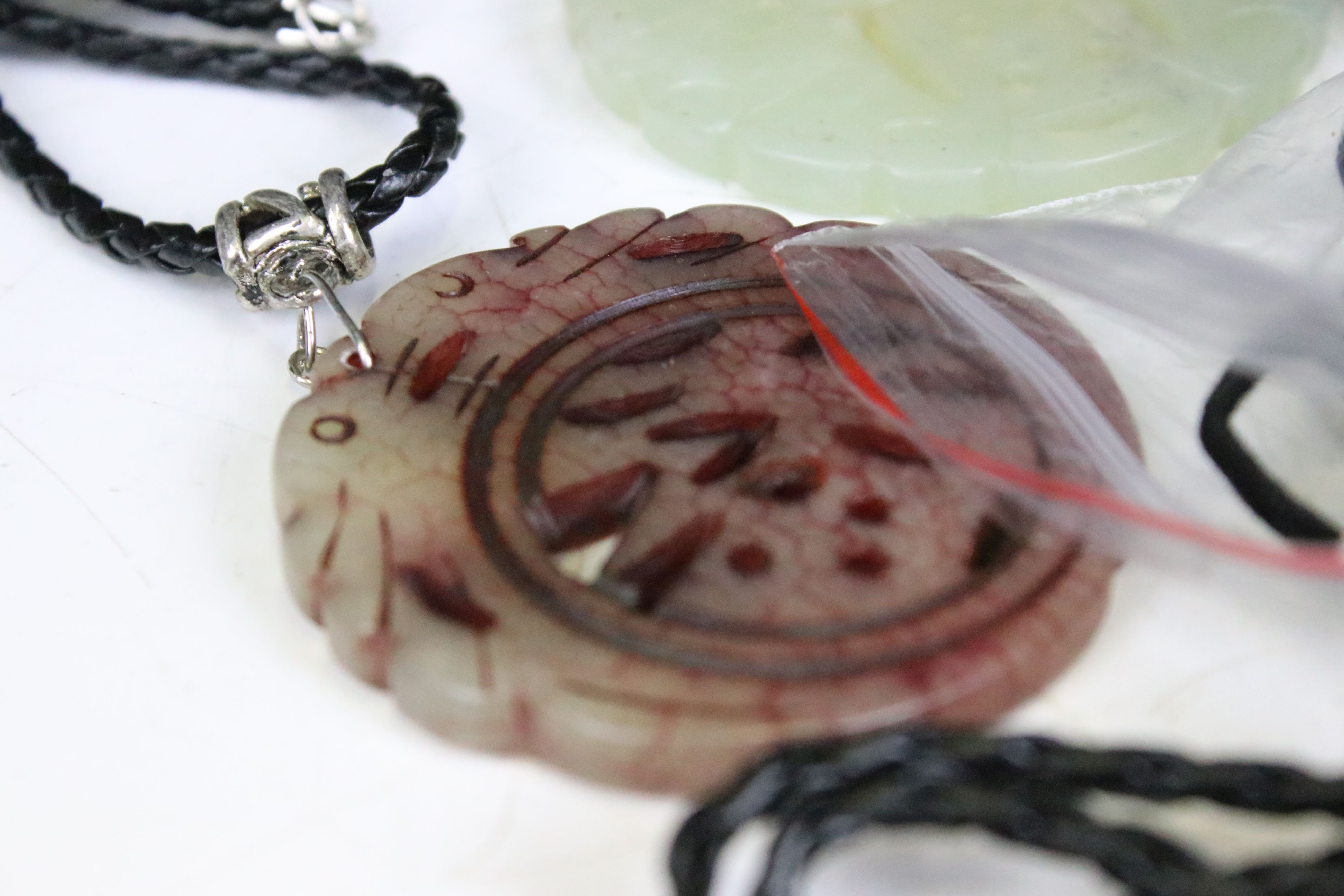 A collection of twenty seven carved jade pendants on leather / hessian necklaces. - Image 6 of 6