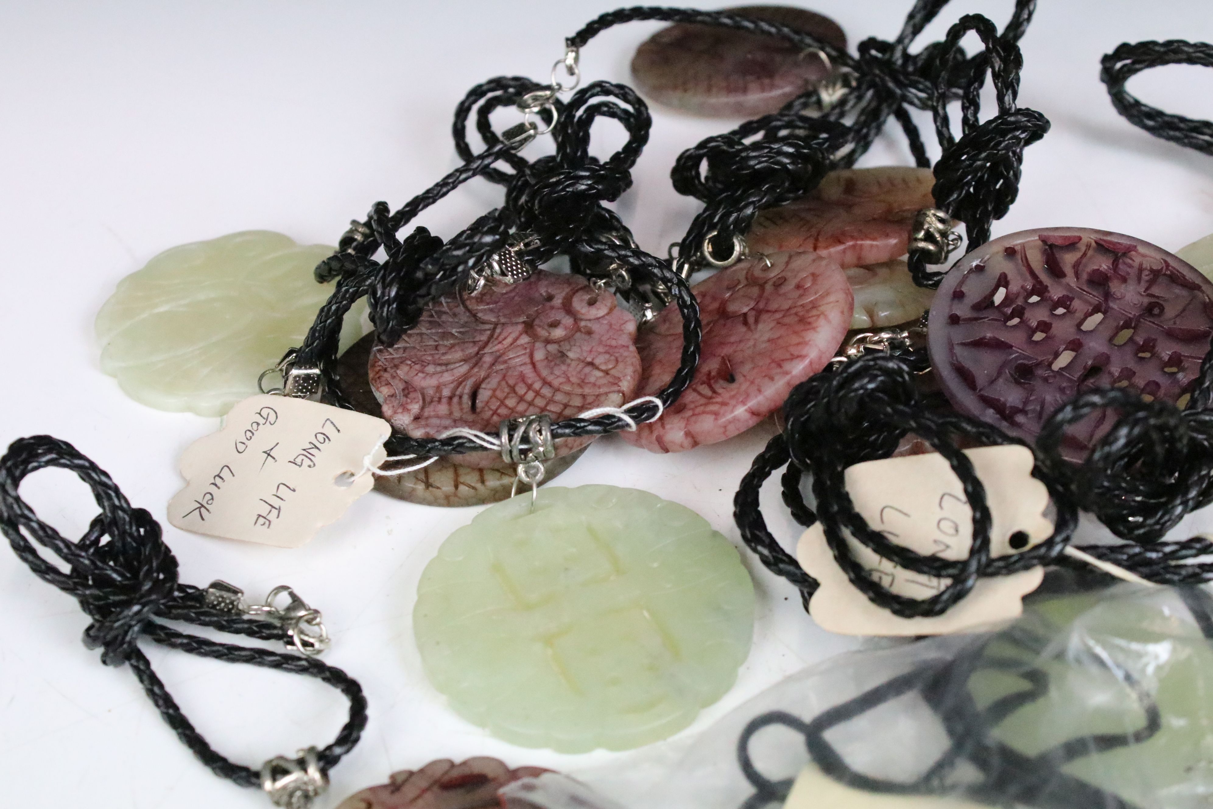 A collection of twenty seven carved jade pendants on leather / hessian necklaces. - Image 4 of 6