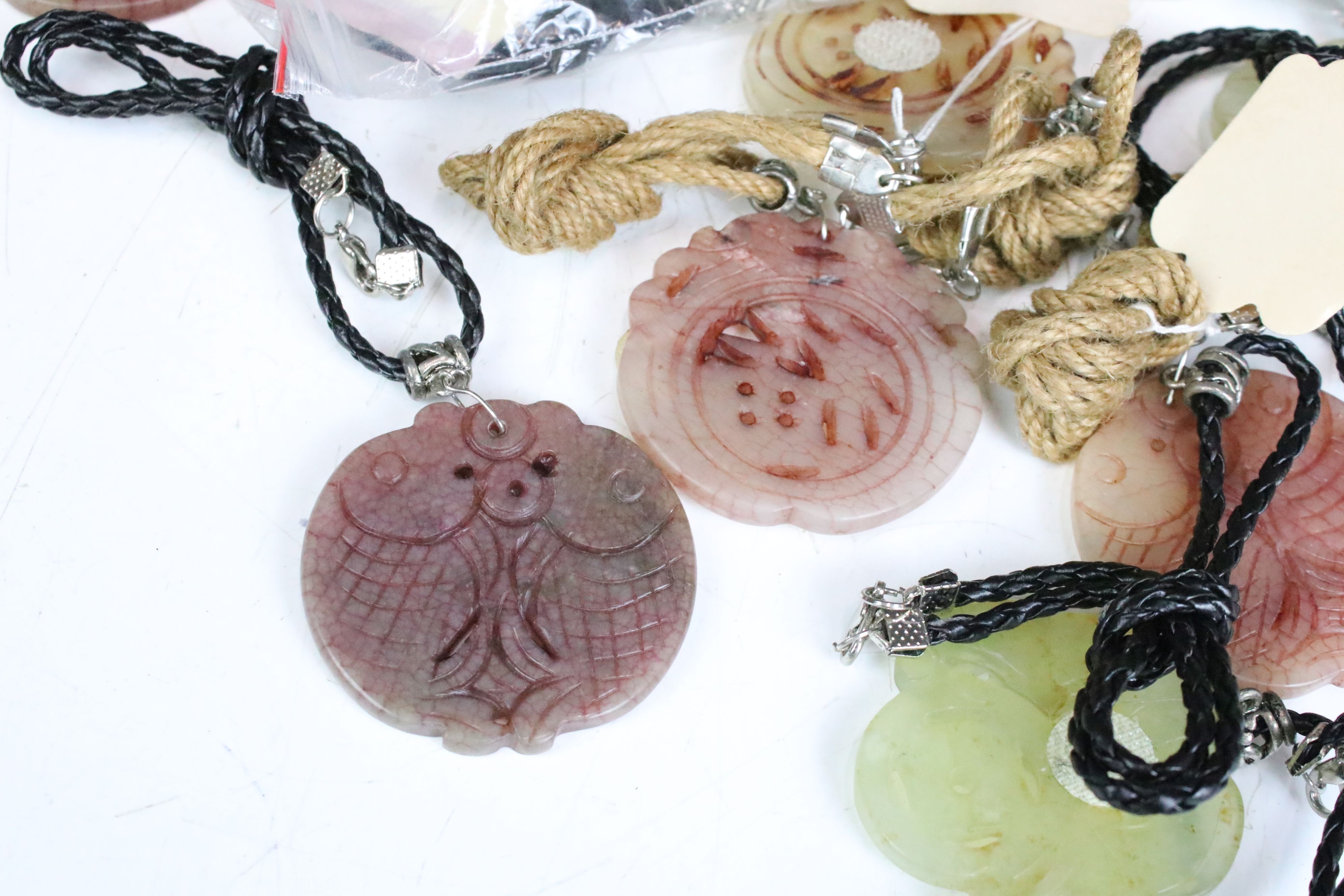 A collection of twenty seven carved jade pendants on leather / hessian necklaces. - Image 2 of 6