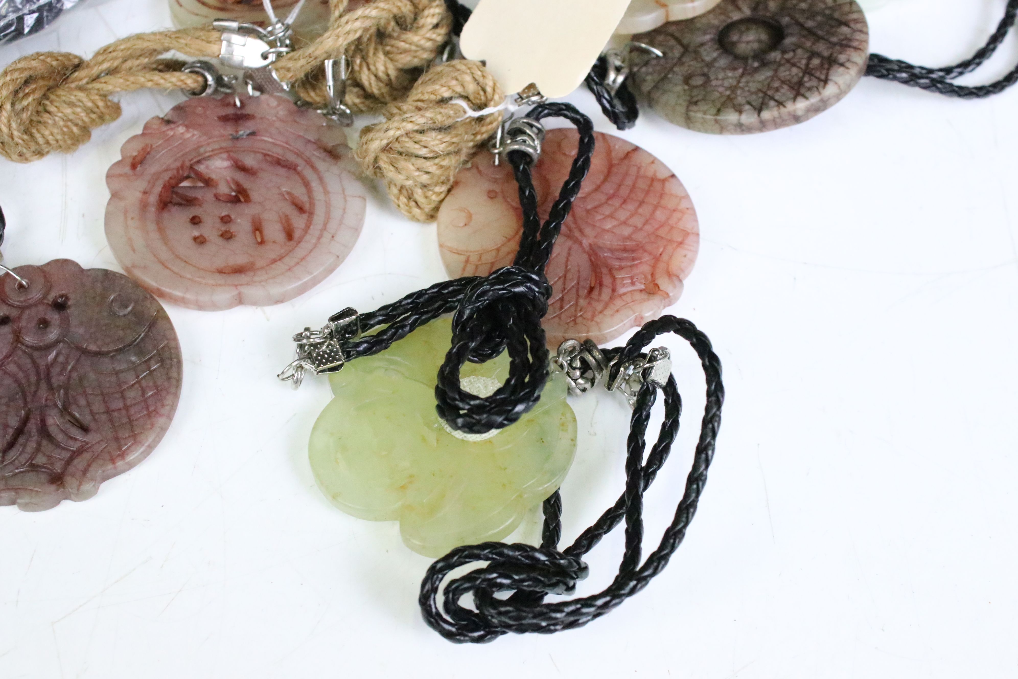 A collection of twenty seven carved jade pendants on leather / hessian necklaces. - Image 3 of 6
