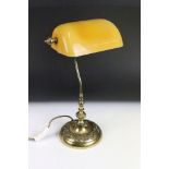 A brass desk / bankers lamp with amber glass shade.