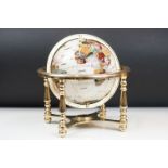 A contemporary table top globe made with semi precious stones on gilt metal frame with compass to