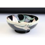 Moorcroft - a small bowl with tube lined lily detailing on a black background. Impressed Moorcroft
