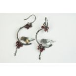 A pair of white metal ladies drop earrings with bird decoration.