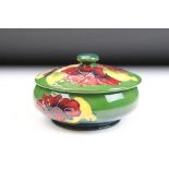 20th Century Moorcroft lidded pot featuring tube lined hibiscus flowers with a squat body and finial