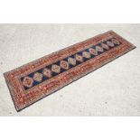 Eastern Red and Blue Ground Wool Runner Rug decorated with thirteen guls within a deep border,