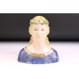 Ceramic figurine bust being hand modelled in to the form of a medieval maiden wearing a flower crown