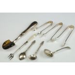 Three silver sugar tongs, a millennium cheese scoop and other spoons