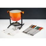 Le Creuset cast iron fondue set complete with stand, burner and twelve sticks. Measures 21 x 22cm.