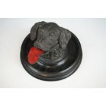 A Victorian pewter inkwell in the form of a dogs head mounted on a turned black wooden base,