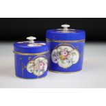 Two porcelian dressing table pots, each having a blue ground with hand painted floral panels.