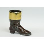 A cast metal match striker in the form of a boot with brass surround.