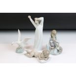 Four Lladro ceramic figurines to include a sleeping baby, swan, girl with puppies and yawning boy.