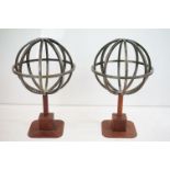 Pair of Armorial decorative metal spheres each raised on pedestal bases upholstered in leather.