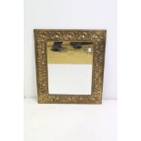 Arts and Crafts Brass Framed Rectangular Mirror with embossed shell and scroll foliate decoration,