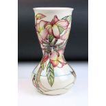 20th Century Moorcroft waisted vase having tube lined floral detailing upon a cream ground.