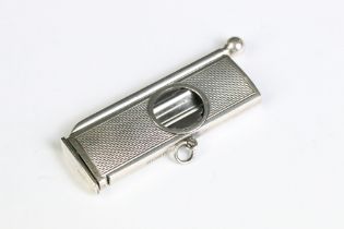 A fully hallmarked sterling silver cigar cutter with engine turned decoration, assay marked for