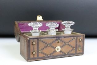 Victorian leather clad dome top casket, housing three glass scent bottles & stoppers (1 a/f), the