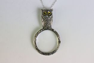 A silver owl shaped magnifying pendant necklace