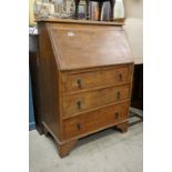 Early 20th century Oak Bureau, the sloping front opening to a fitted interior over three drawers,