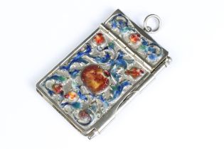 A white metal and enamel pocket notebook with floral enamel decoration.