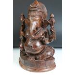 Carved hardwood sculpture depicting the Hindu god Ganesh, raised on a pedestal base, measures approx