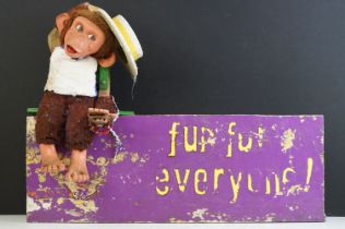 'Fun for everyone!' painted wooden fairground sign, surmounted by a mechanical monkey with