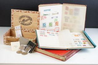 A small collection of British and world stamps contained within three albums together with a small