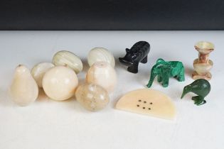 A collection of carved stone eggs together with a carved malachite elephant, Kiwi and a Hippo.