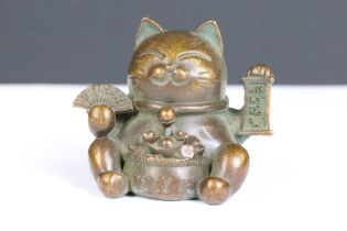 An ornamental Japanese bronze 招き猫 / maneki-neko (waving / beckoning) lucky cat talisman.