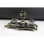 Cast iron double inkwell desk stand, painted in black with gilt details, with twin glass inkwells.