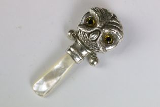 A silver owl shaped babies rattle