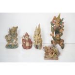 Five South-East Asian painted wooden carvings to include a Burmese Kneeling Buddha, figural pulley