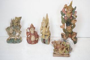 Five South-East Asian painted wooden carvings to include a Burmese Kneeling Buddha, figural pulley