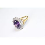 A silver ring set with a substantial amethyst surrounded by CZ