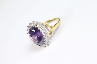 A silver ring set with a substantial amethyst surrounded by CZ