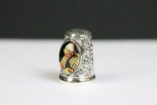 A silver thimble with enamel panel