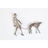 A silver brooch set with marcasites in the form of an art deco figure and her dog