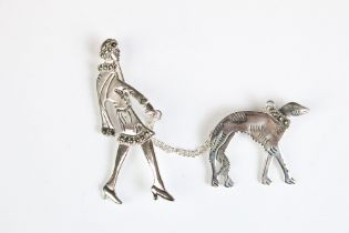 A silver brooch set with marcasites in the form of an art deco figure and her dog