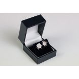 A pair of silver and CZ sunburst stud earrings