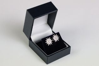 A pair of silver and CZ sunburst stud earrings