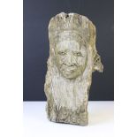 Carving of a face, of organic form, on a wooden tree branch (approx 37cm wide)
