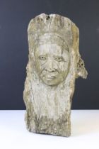 Carving of a face, of organic form, on a wooden tree branch (approx 37cm wide)