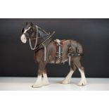 Beswick shire horse figurine having a matte / bisque finish fitted with cart pulling harnesses.