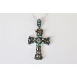 A silver pendant cross set with turquoise and ruby cabochons.