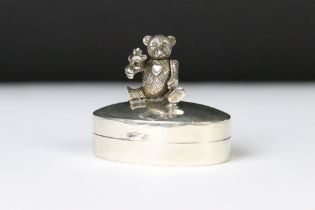 A silver oval pill box with articulated bear to the lid.